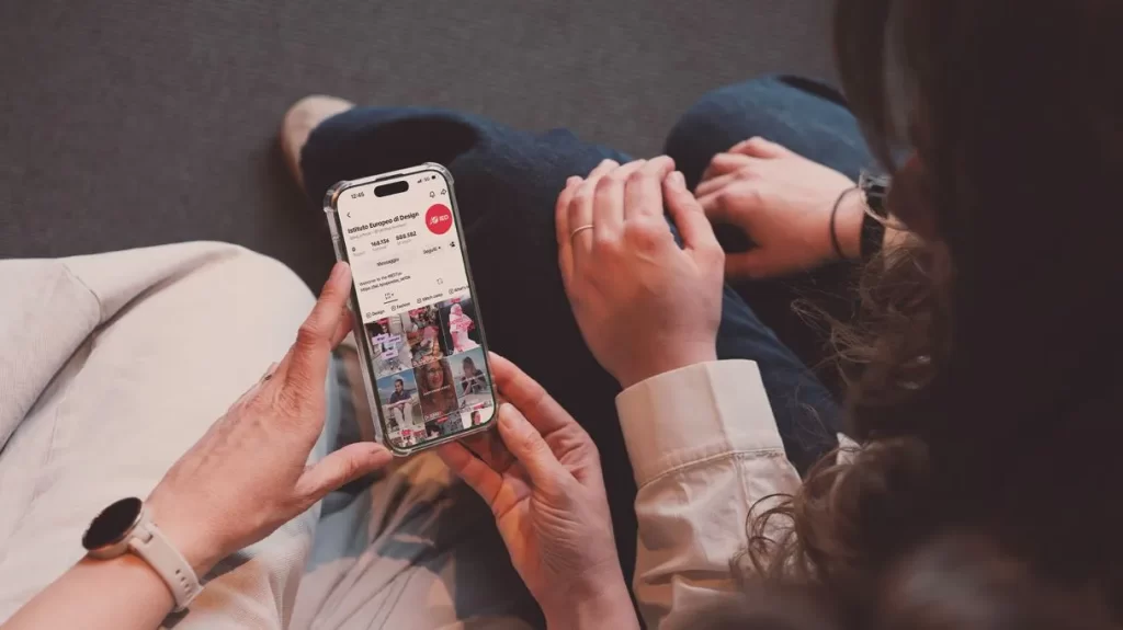 A student checks the IED TikTok profile on her smartphone.